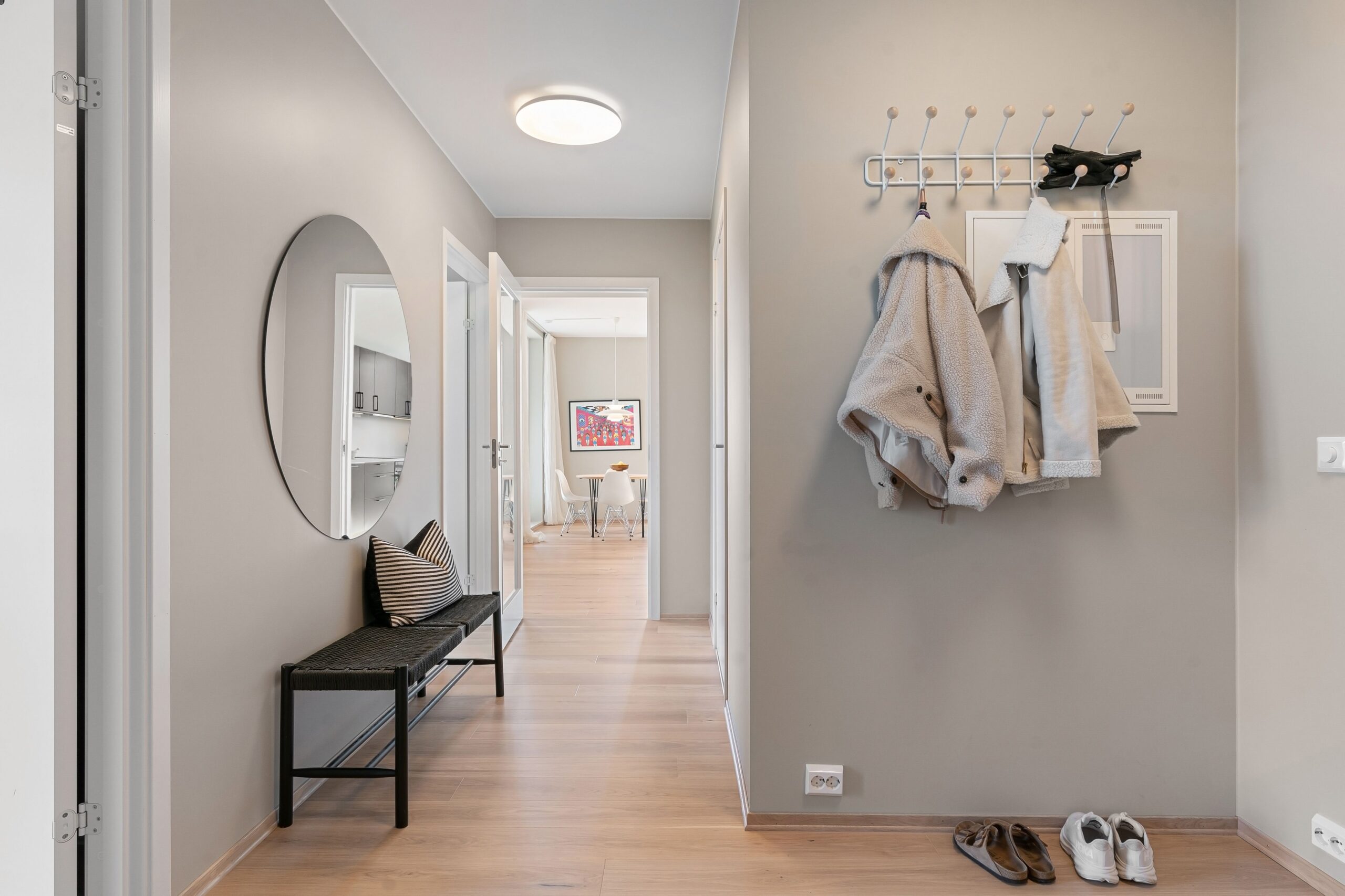 Entryway with a round mirror, black bench and coat rack for a fall reset