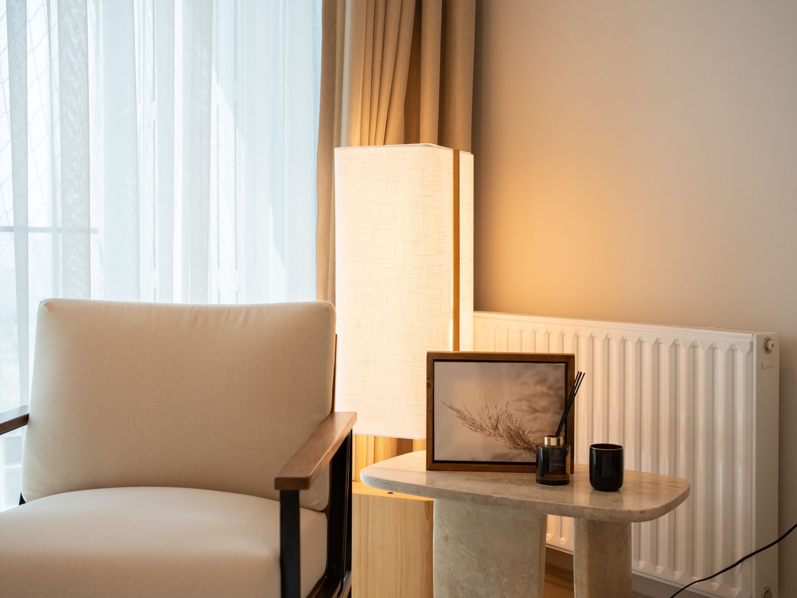 Light coming through a window and curtains into a calm, simple living room