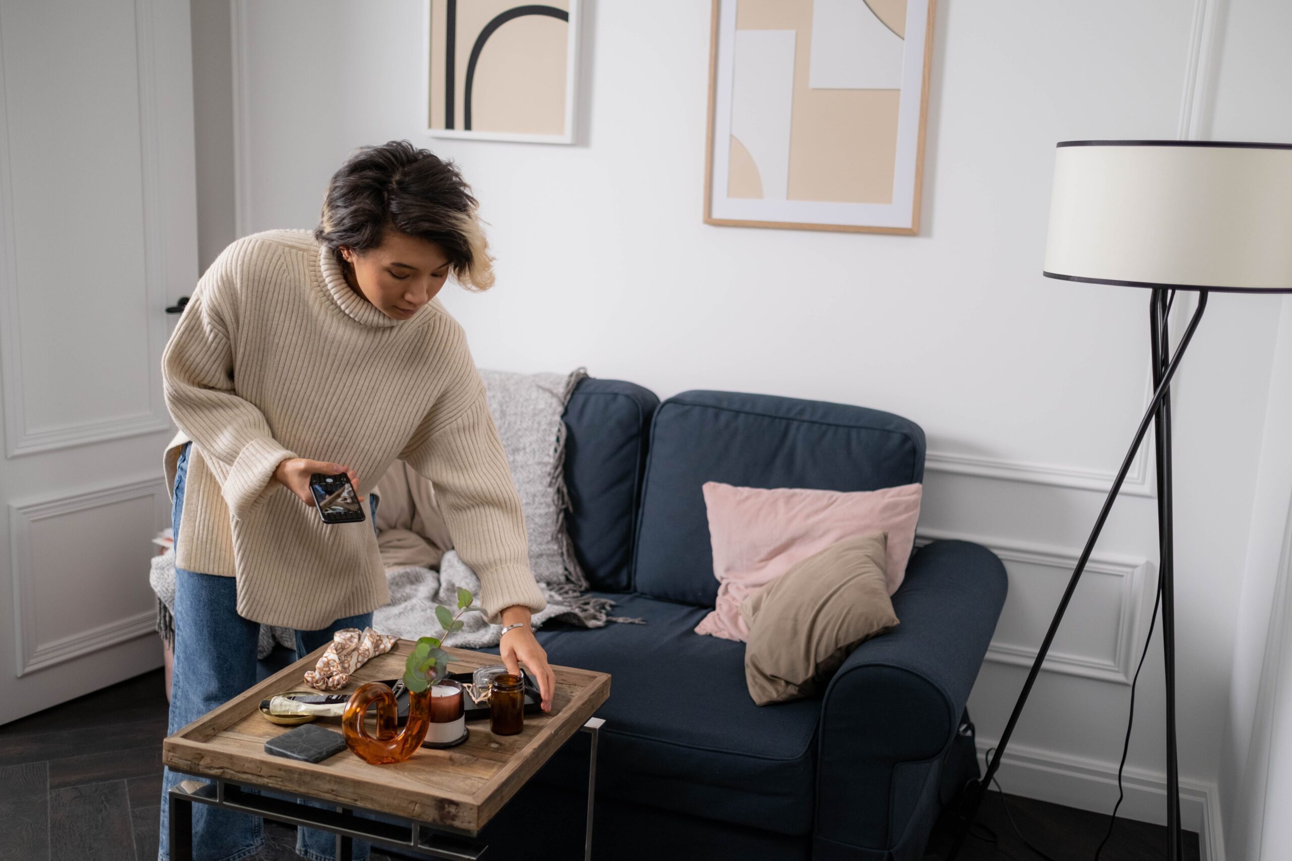 A woman relaxing on a sofa with a throw blanket in a cozy, softly lit living room