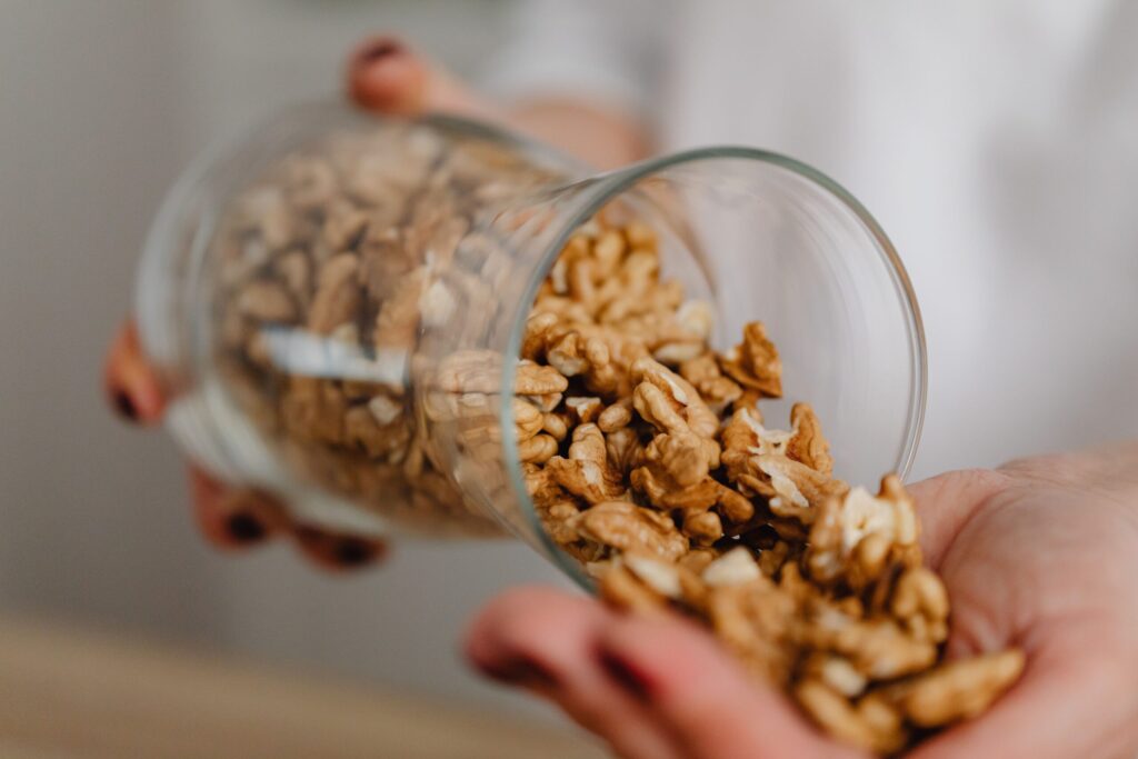 Nuts being poured from a glass jar