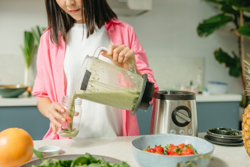 Woman blending a smoothie in a bright kitchen