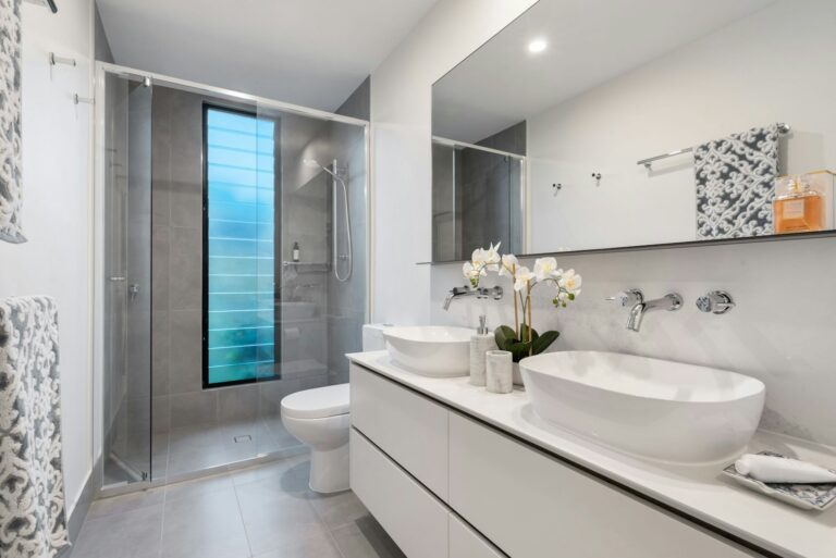 A white sink with a mirror in a bright bathroom