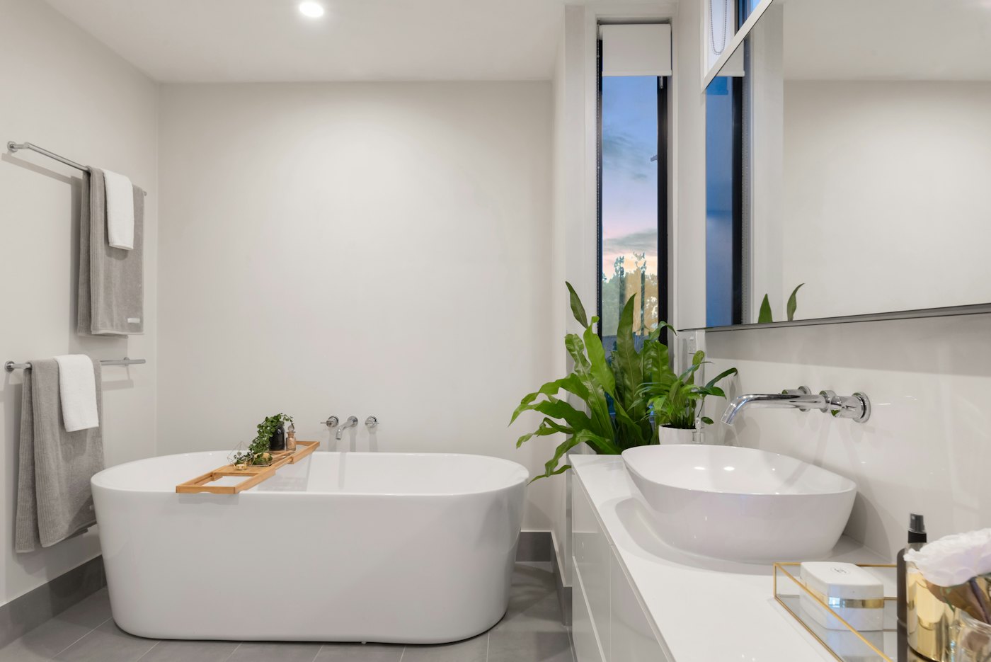 A white bathtub beside a green plant