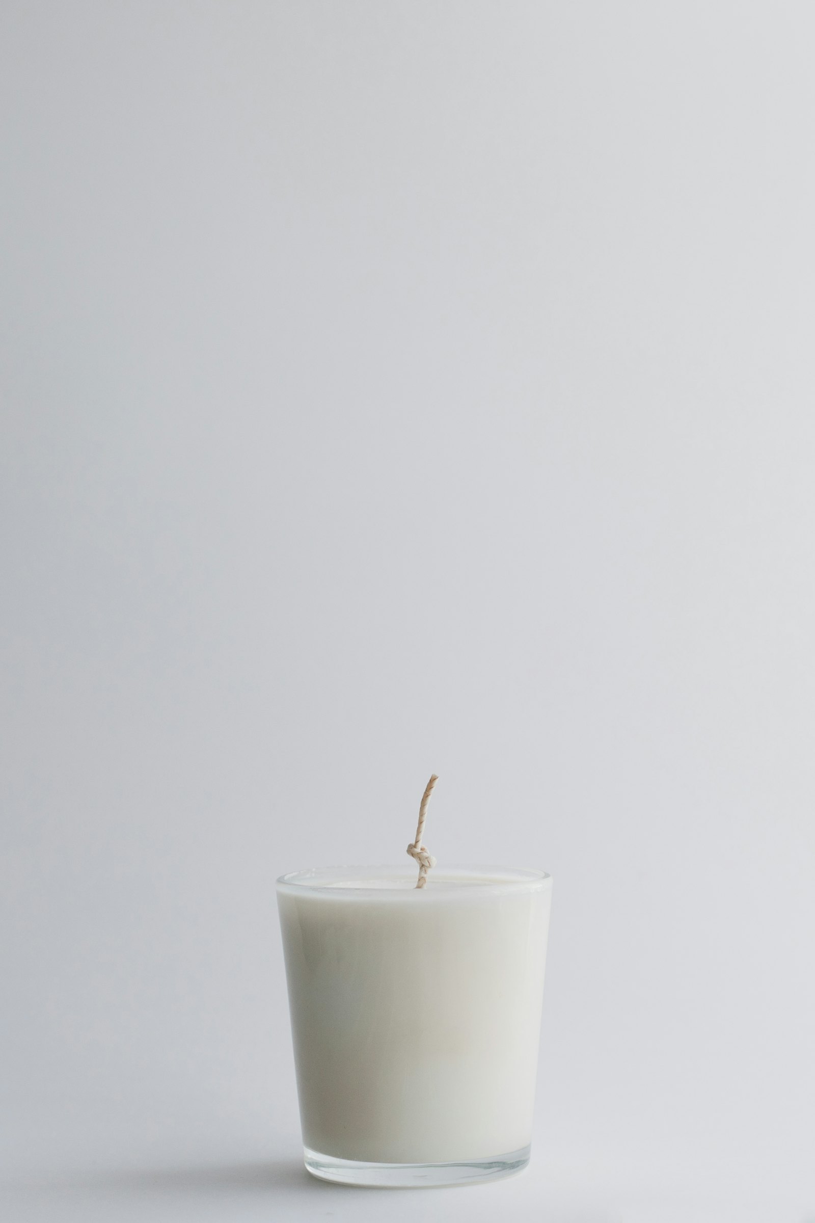 A white candle in a glass jar