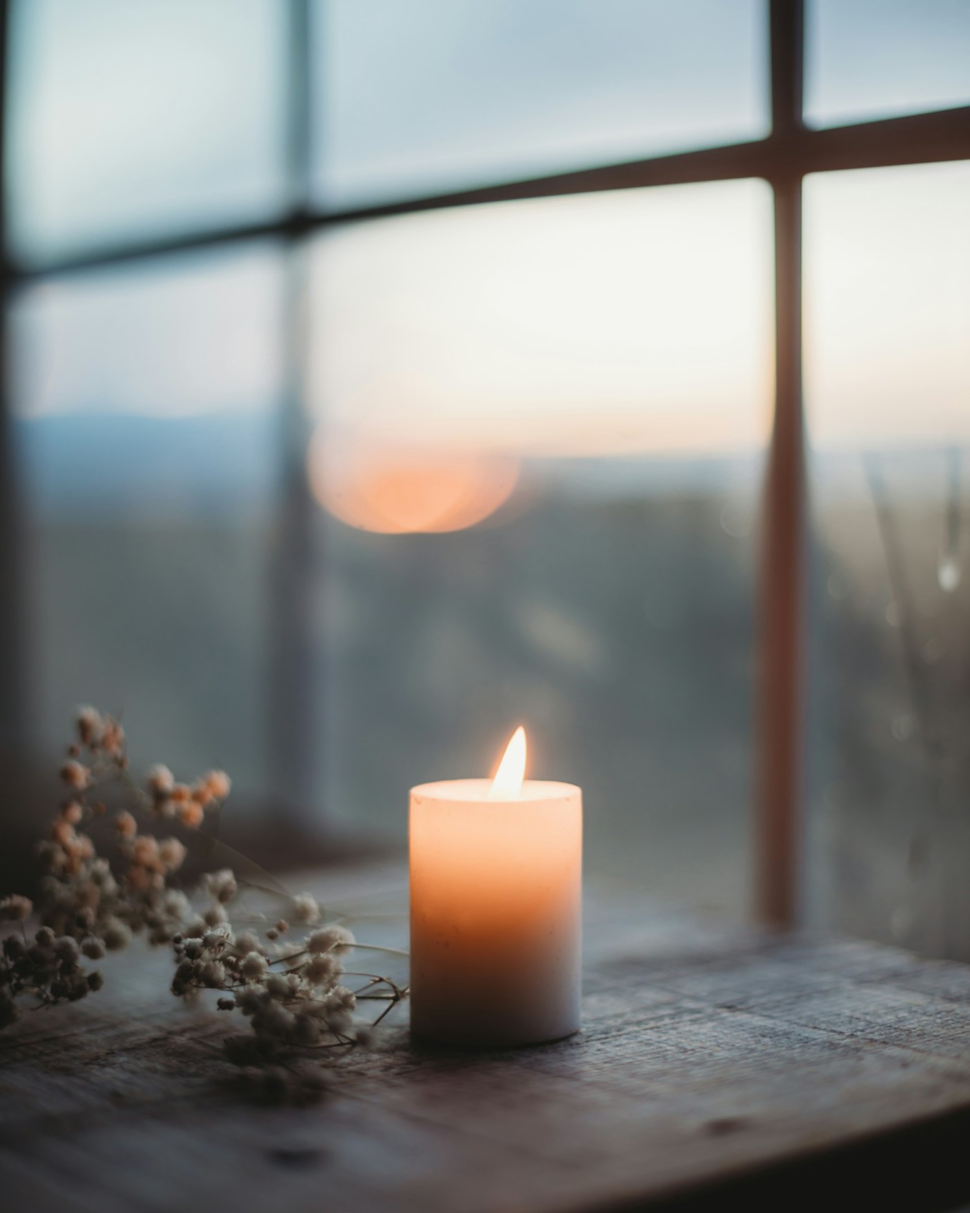 A lit candle on a wooden surface