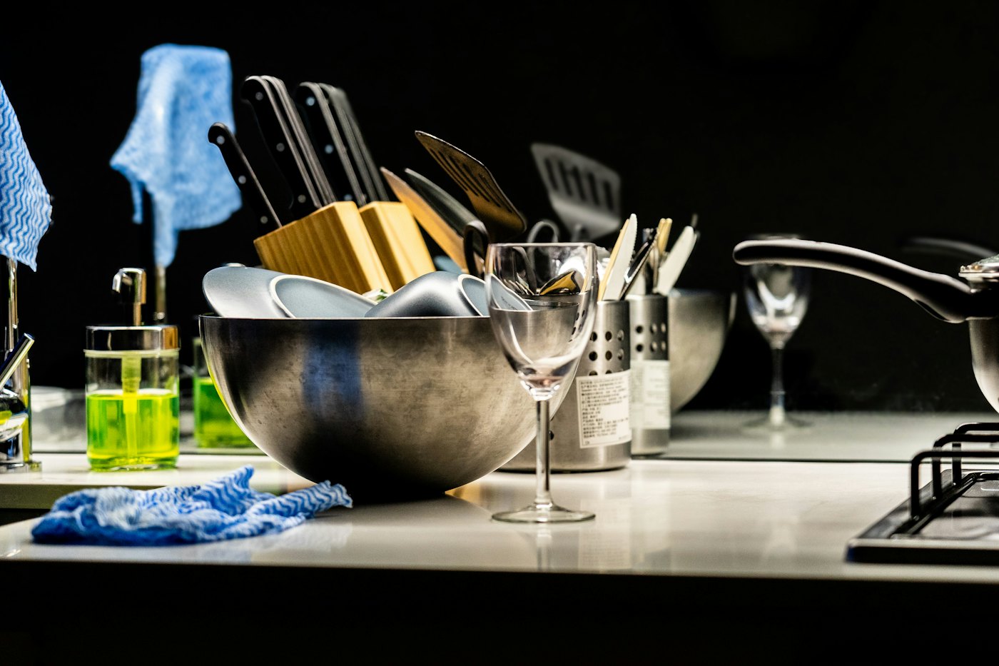A kitchen sink with dishes and cleaning supplies