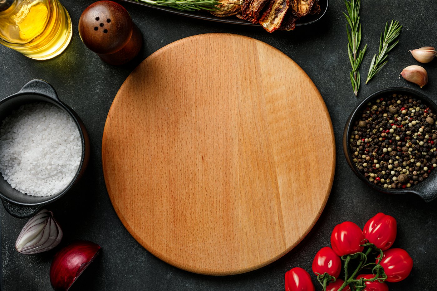 A wooden cutting board surrounded by ingredients