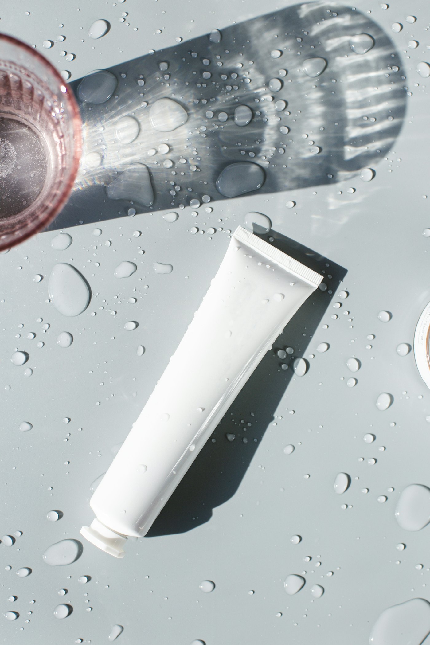 A white skincare tube on a glass table