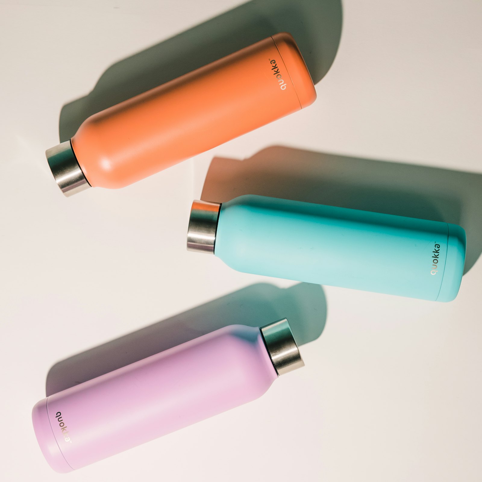 Three colorful stainless steel water bottles